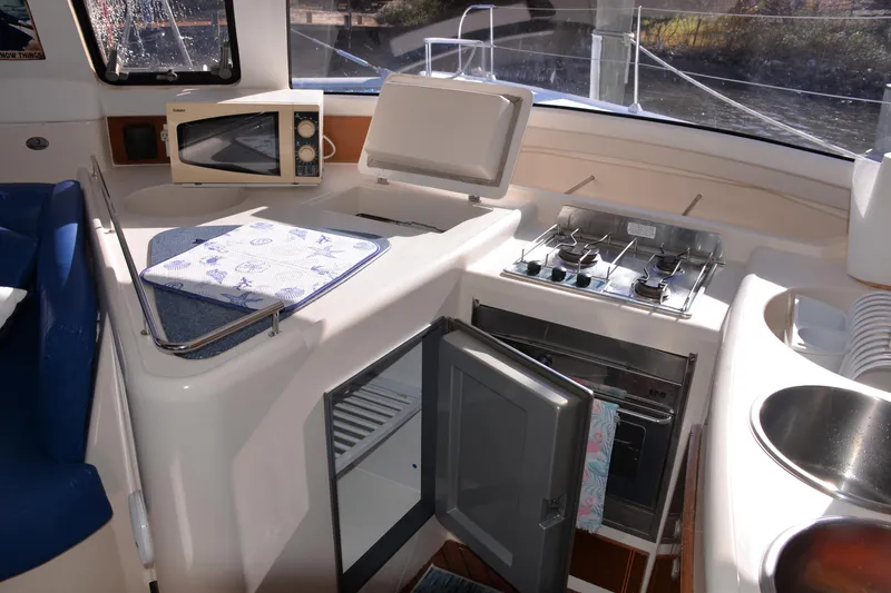 Dreamweaver Yacht Photos Pics 2004 Fountaine Pajot Belize 43 yacht kitchen with stove, microwave, and open fridge.