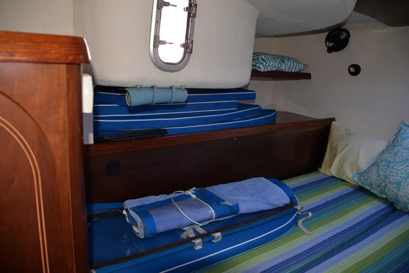 Dreamweaver Yacht Photos Pics Interior cabin of 2004 Fountaine Pajot Belize 43 with striped bedding and storage shelves.