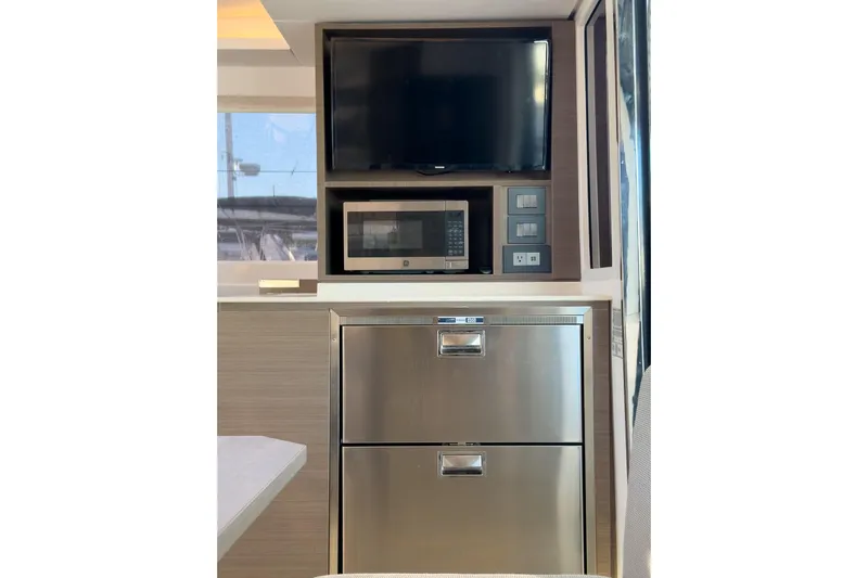 Panthera Yacht Photos Pics Modern kitchen area in 2021 Leopard 42 yacht with TV, microwave, and stainless steel drawers.