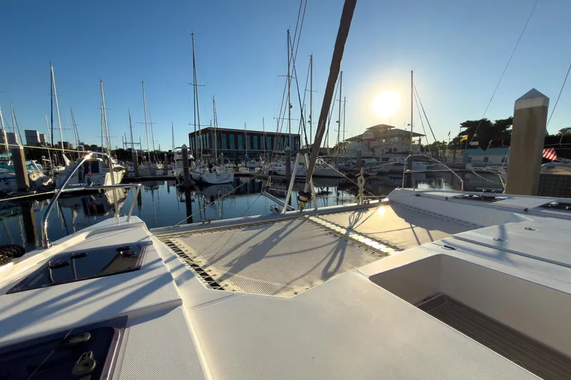 Panthera Yacht Photos Pics 2021 Leopard 42 catamaran docked at marina during sunset, with sailboats in background.