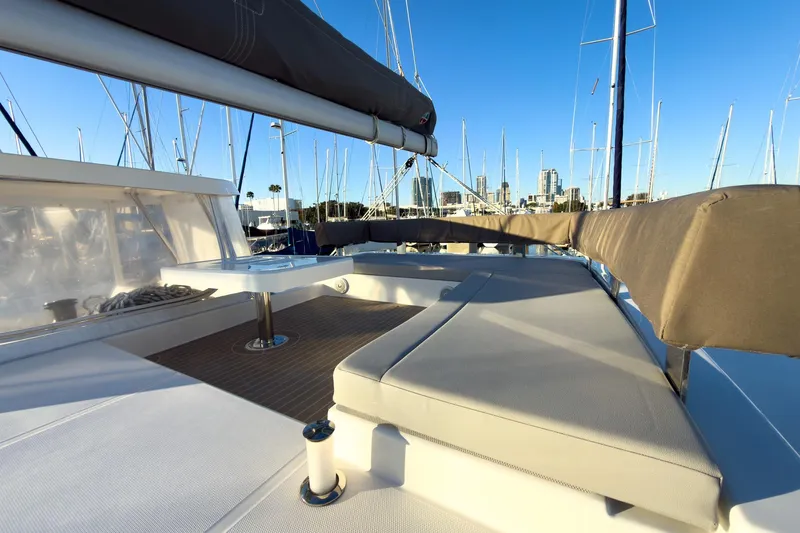 Panthera Yacht Photos Pics 2021 Leopard 42 yacht deck with seating, docked in marina under clear blue sky.