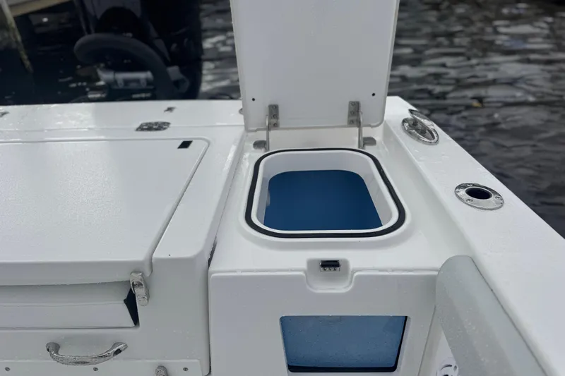 Your Next Boat! Yacht Photos Pics 2026 Blackfin 262 HB boat with open storage compartment by the water.