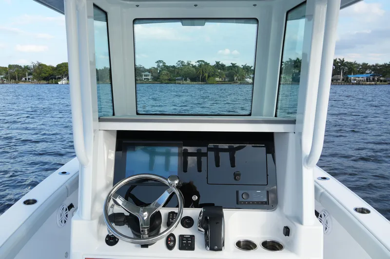 Your Next Boat! Yacht Photos Pics 2026 Blackfin 262 HB boat helm with steering wheel and control panel on open water.