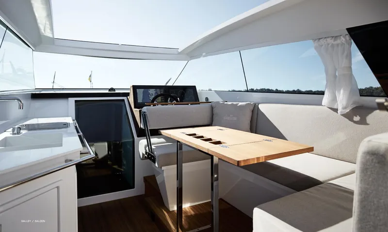  Yacht Photos Pics 2023 Delta Powerboats 33 Coupe interior with modern seating and wooden table.