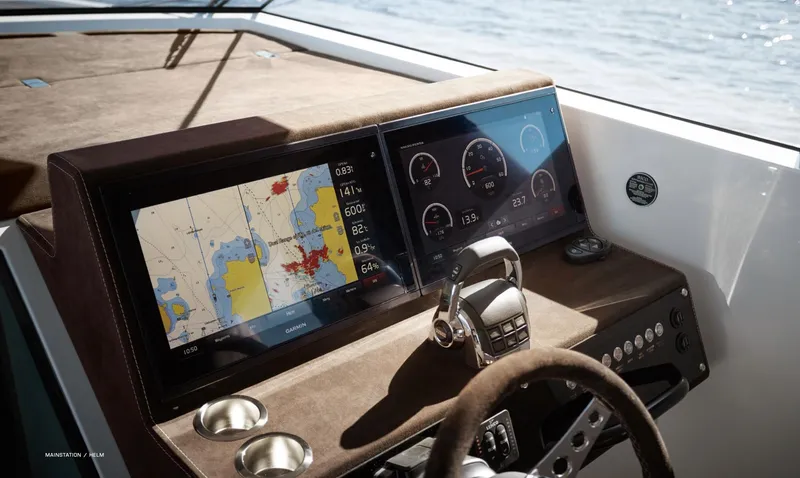  Yacht Photos Pics 2023 Delta Powerboats 33 Coupe dashboard with navigation and control screens, steering wheel, and ocean view.