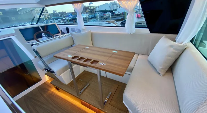  Yacht Photos Pics Interior of 2023 Delta Powerboats 33 Coupe with elegant seating and wooden table.