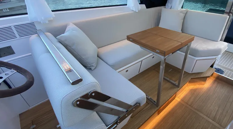  Yacht Photos Pics 2023 Delta Powerboats 33 Coupe interior with modern seating and wooden table.