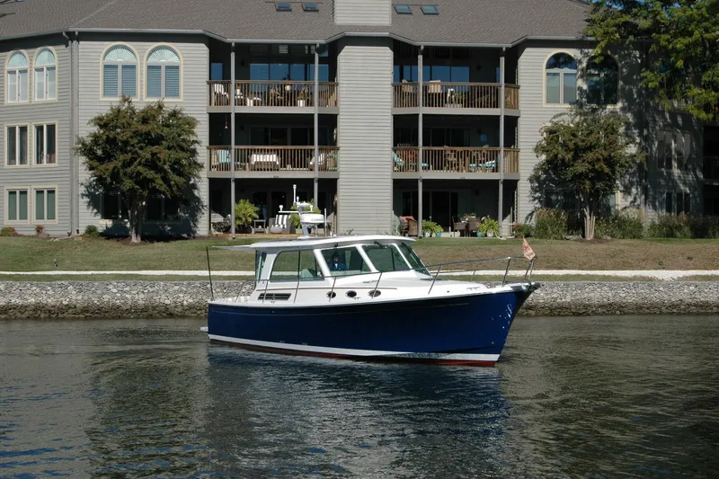 Bonnie Blue Yacht Photos Pics 2015 Back Cove 37 boat on calm water near waterfront apartments.