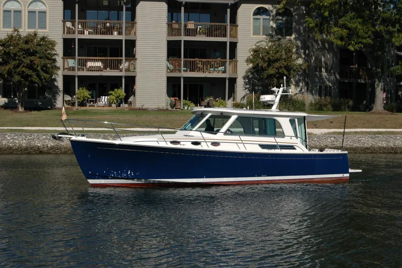 Bonnie Blue Yacht Photos Pics 2015 Back Cove 37 boat on calm water near residential buildings.