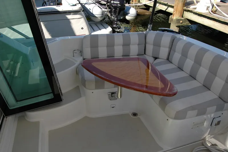 Bonnie Blue Yacht Photos Pics 2015 Back Cove 37 boat with striped seating and triangular wooden table.