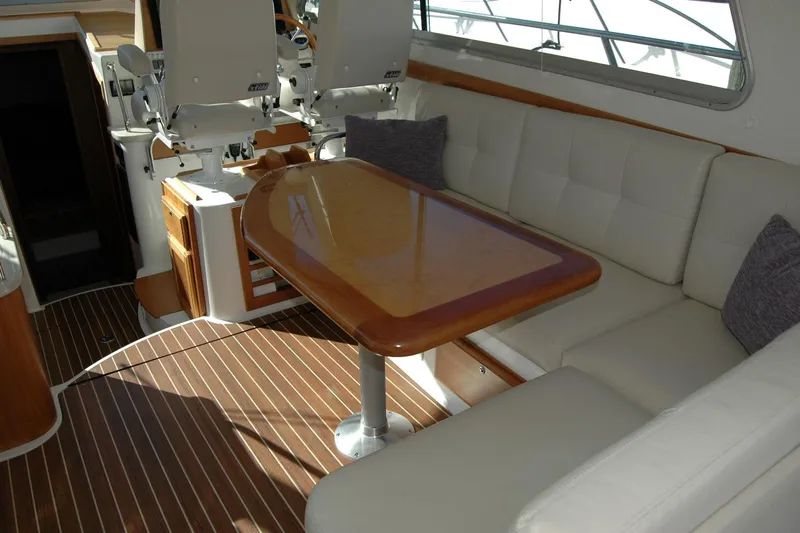 Bonnie Blue Yacht Photos Pics 2015 Back Cove 37 yacht interior with cushioned seating and wooden table.