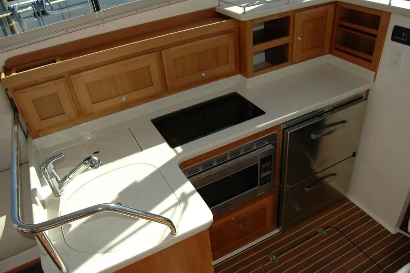 Bonnie Blue Yacht Photos Pics 2015 Back Cove 37 yacht kitchen with sink, stove, microwave, and wooden cabinetry.