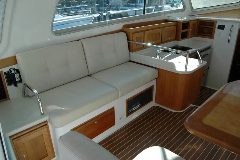 Bonnie Blue Yacht Photos Pics 2015 Back Cove 37 yacht interior with beige seating and wooden cabinetry.