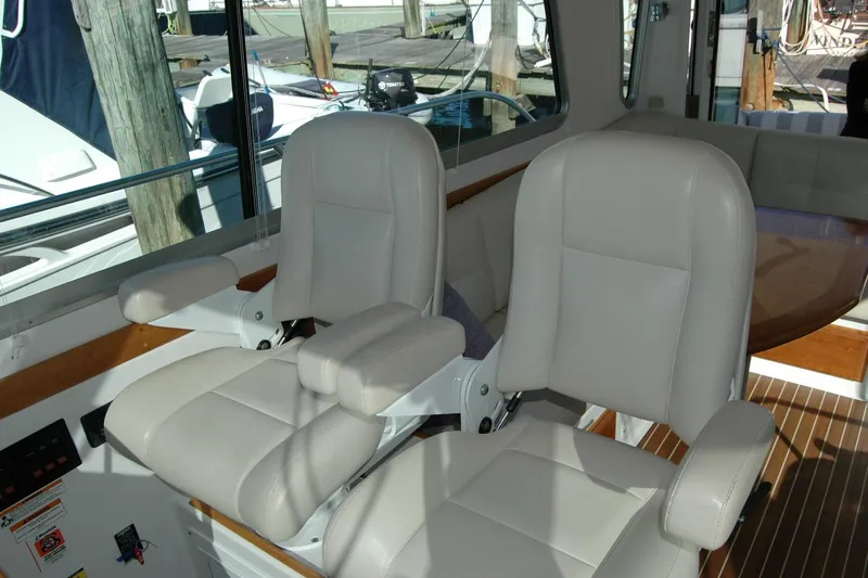 Bonnie Blue Yacht Photos Pics 2015 Back Cove 37 interior with two white captain chairs and wooden accents.