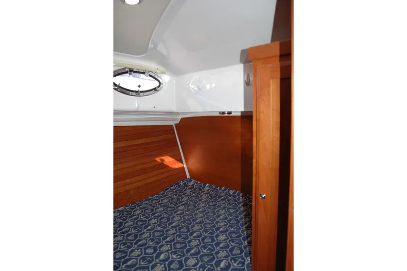 Bonnie Blue Yacht Photos Pics 2015 Back Cove 37 interior cabin with wood paneling and patterned bedding.