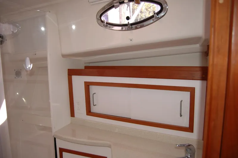 Bonnie Blue Yacht Photos Pics 2015 Back Cove 37 yacht interior with wooden cabinetry and porthole window.