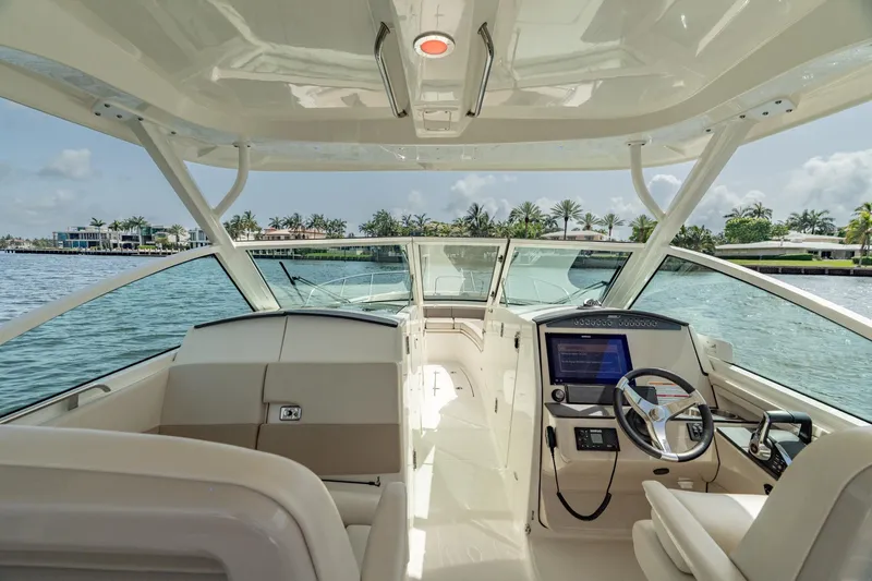 Giorgia I Yacht Photos Pics 2024 Boston Whaler 320 Vantage boat interior with helm, steering wheel, and waterfront view.