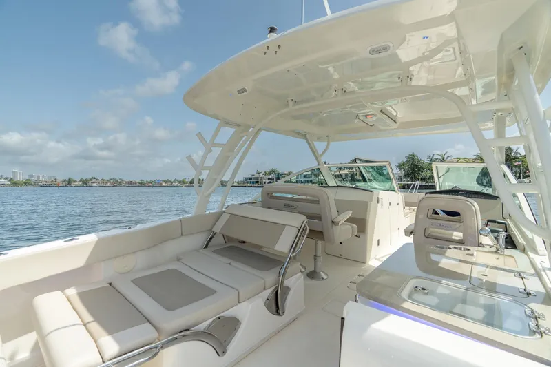 Giorgia I Yacht Photos Pics 2024 Boston Whaler 320 Vantage boat interior with seating and helm, on a sunny day.