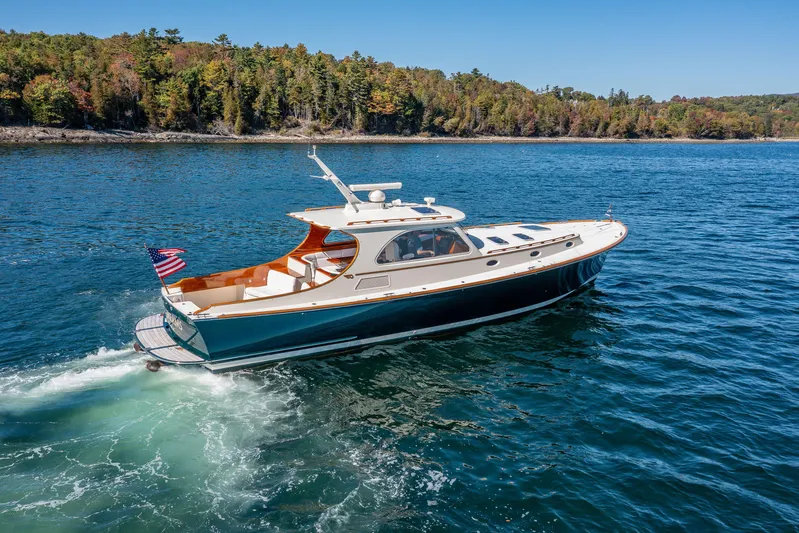 Pipe Dreams Yacht Photos Pics 2002 Hinckley Talaria 44 Express cruising on a scenic lake with forested shoreline.