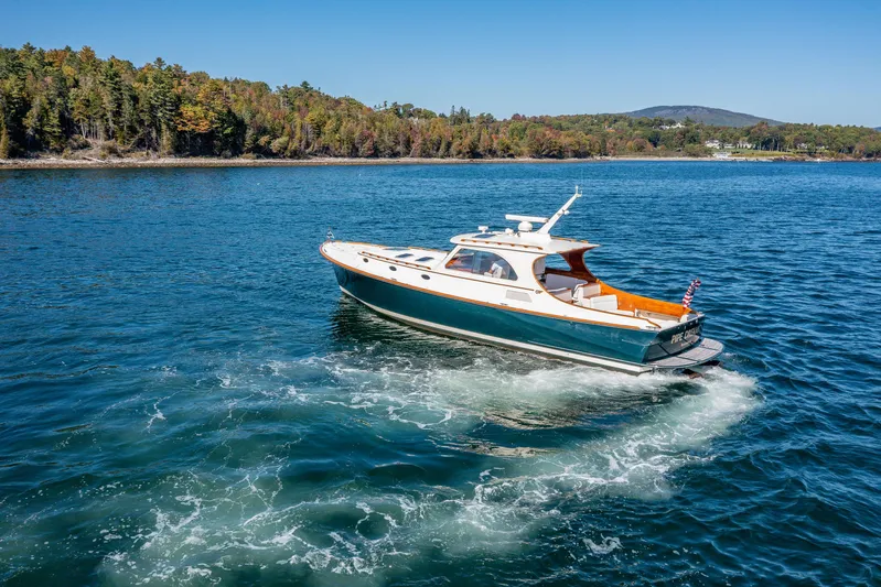 Pipe Dreams Yacht Photos Pics 2002 Hinckley Talaria 44 Express cruising on a scenic lake with forested shoreline.