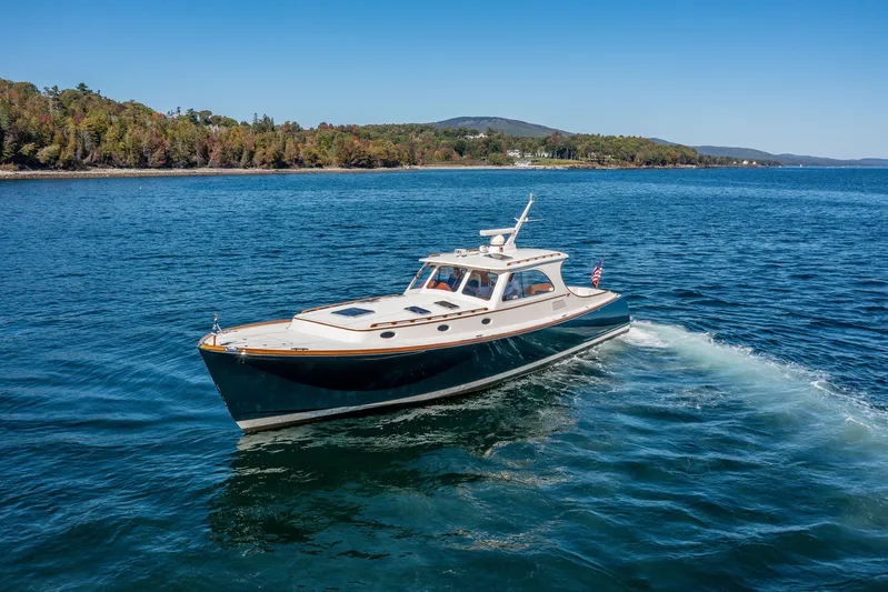 Pipe Dreams Yacht Photos Pics 2002 Hinckley Talaria 44 Express yacht cruising on a scenic lake.