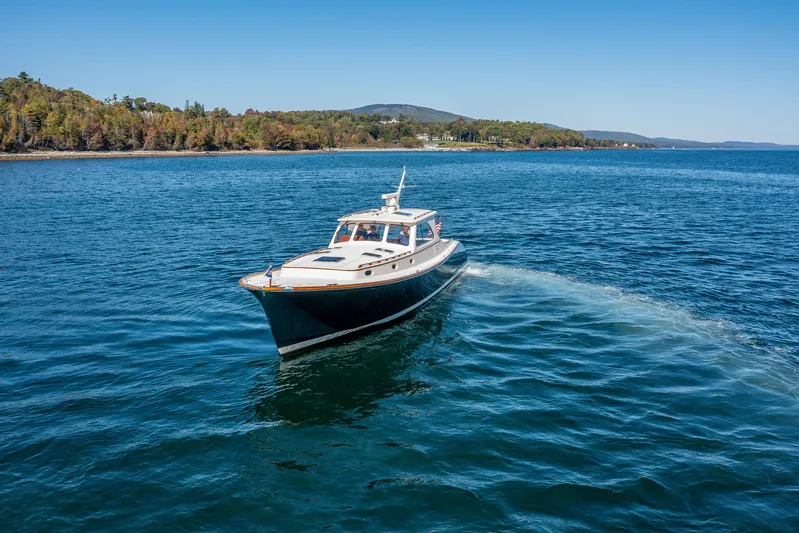 Pipe Dreams Yacht Photos Pics 2002 Hinckley Talaria 44 Express cruising on a scenic lake with forested shoreline.