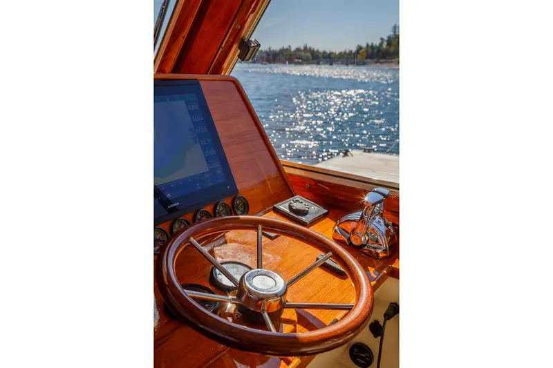 Pipe Dreams Yacht Photos Pics Helm of 2002 Hinckley Talaria 44 Express with wooden steering wheel and navigation screen.