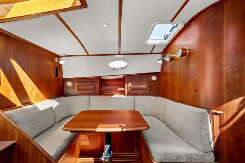 Pipe Dreams Yacht Photos Pics Interior of 2002 Hinckley Talaria 44 Express with wooden paneling and cozy seating area.
