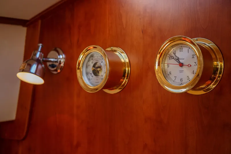 Pipe Dreams Yacht Photos Pics Wall-mounted clock and barometer on Hinckley Talaria 44 Express, 2002 model, with wooden paneling.
