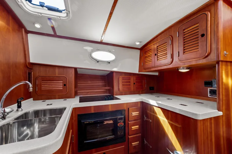 Pipe Dreams Yacht Photos Pics Luxurious 2002 Hinckley Talaria 44 Express yacht kitchen with wood cabinetry and modern appliances.