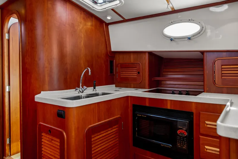Pipe Dreams Yacht Photos Pics Luxurious 2002 Hinckley Talaria 44 Express yacht kitchen with wood cabinetry and modern appliances.