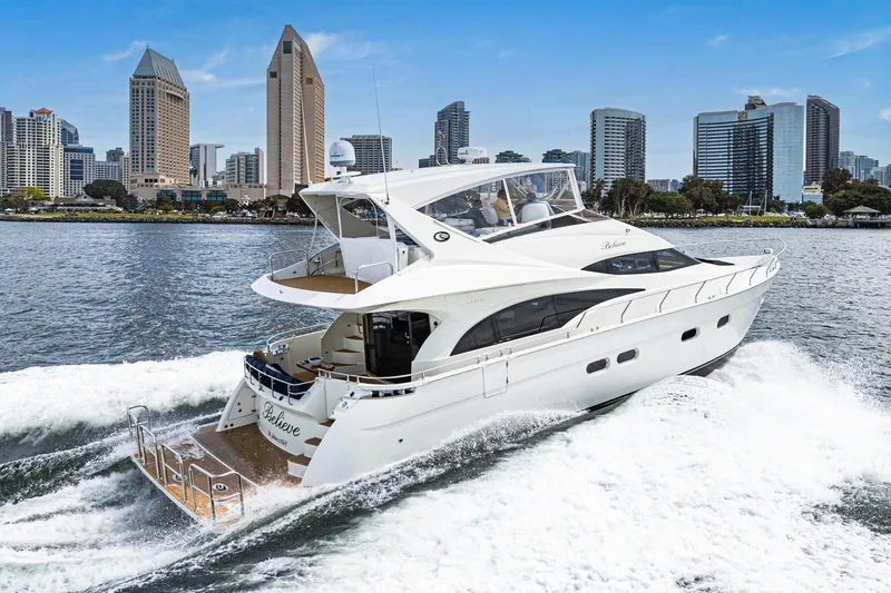 Believe Yacht Photos Pics 2004 Marquis Motor Yacht cruising near city skyline on a sunny day.