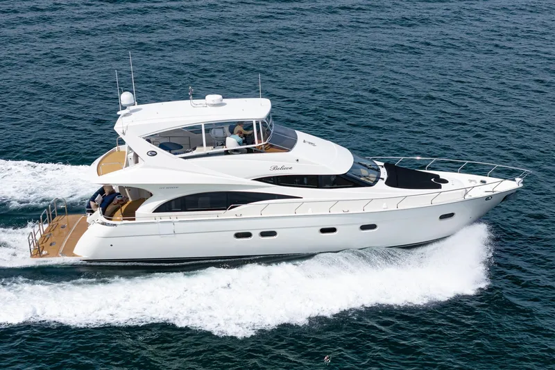 Believe Yacht Photos Pics 2004 Marquis Motor Yacht cruising on open water, showcasing sleek design and luxury.