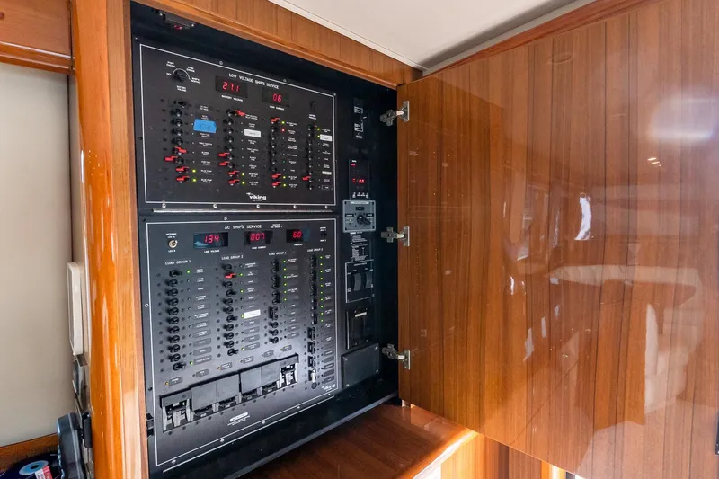 "five Seas" Yacht Photos Pics Electrical panel inside 2007 Viking 64 Convertible yacht with wooden cabinet.