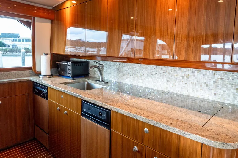 "five Seas" Yacht Photos Pics Luxurious kitchen interior of 2007 Viking 64 Convertible yacht with wood cabinetry and granite countertops.