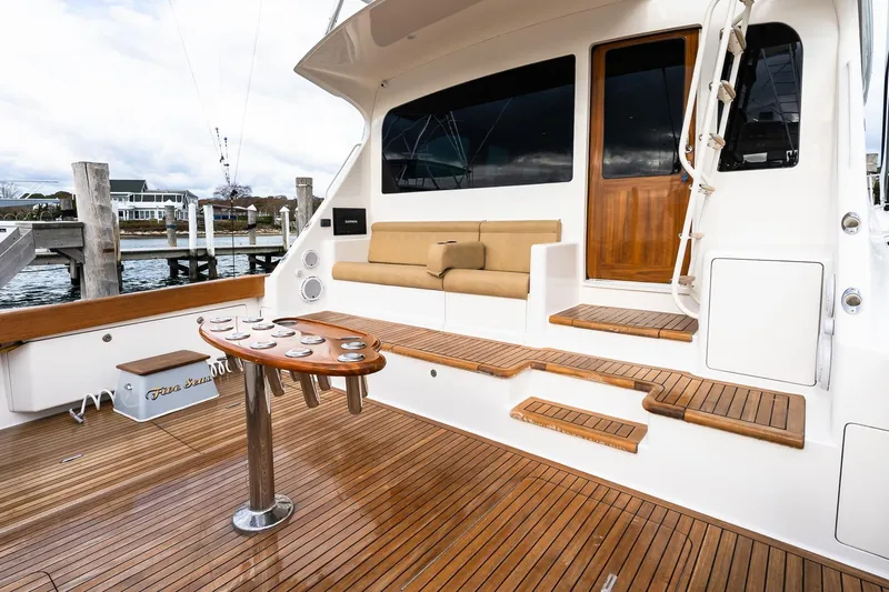 "five Seas" Yacht Photos Pics 2007 Viking 64 Convertible yacht deck with wooden seating and fishing rod holders.