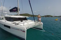 A 2019 Leopard 45 catamaran anchored in clear blue water with people on deck.