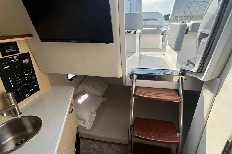  Yacht Photos Pics 2024 Regal 26 XO cabin interior with kitchenette, TV, and access to deck.
