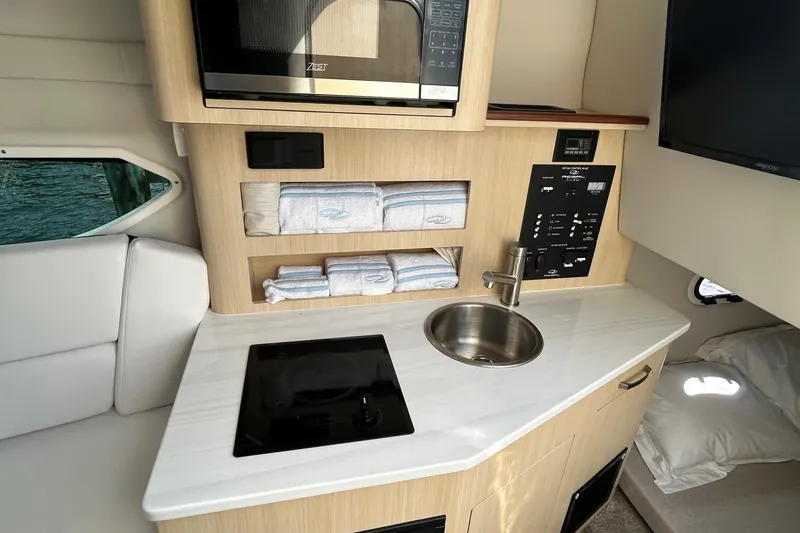  Yacht Photos Pics 2024 Regal 26 XO boat interior with kitchenette, sink, and microwave.