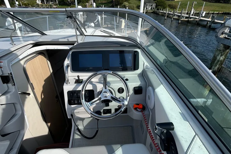  Yacht Photos Pics 2024 Regal 26 XO boat cockpit with steering wheel and dual screens, dockside view.