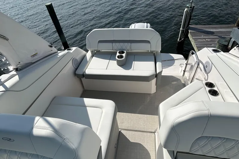  Yacht Photos Pics 2024 Regal 26 XO boat interior with white seating and cup holders by the water.