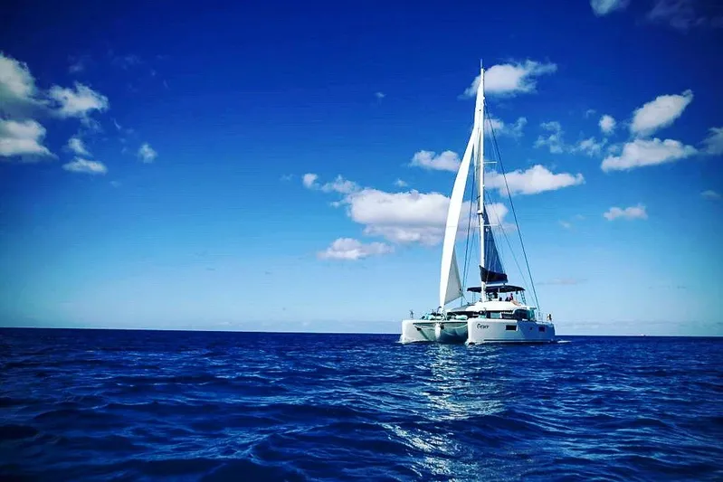 Grace Yacht Photos Pics 2020 Lagoon 52 F catamaran sailing on open ocean under clear blue sky.