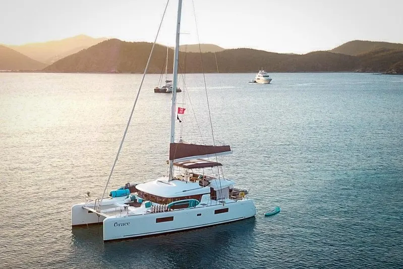 Grace Yacht Photos Pics 2020 Lagoon 52 F catamaran sailing in serene waters at sunset.