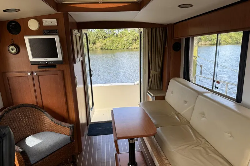 Getaway Yacht Photos Pics Interior of 2008 Mainship 34 Trawler Hardtop with sofa, table, and river view.