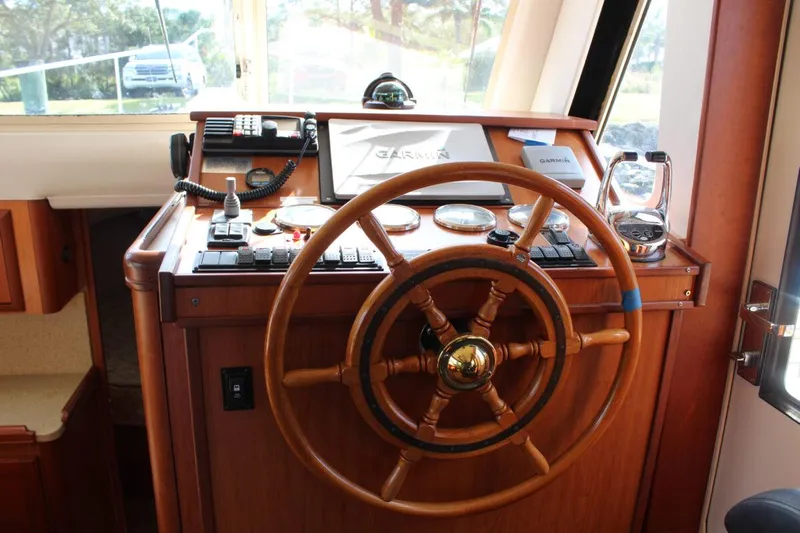 Getaway Yacht Photos Pics Helm of 2008 Mainship 34 Trawler Hardtop with wooden steering wheel and navigation instruments.