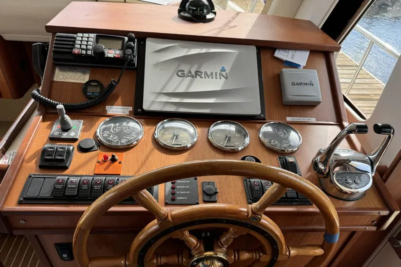 Getaway Yacht Photos Pics 2008 Mainship 34 Trawler Hardtop helm with Garmin navigation and classic wooden steering wheel.