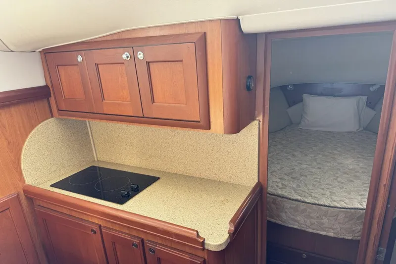 Getaway Yacht Photos Pics 2008 Mainship 34 Trawler Hardtop interior with kitchenette and cozy sleeping area.