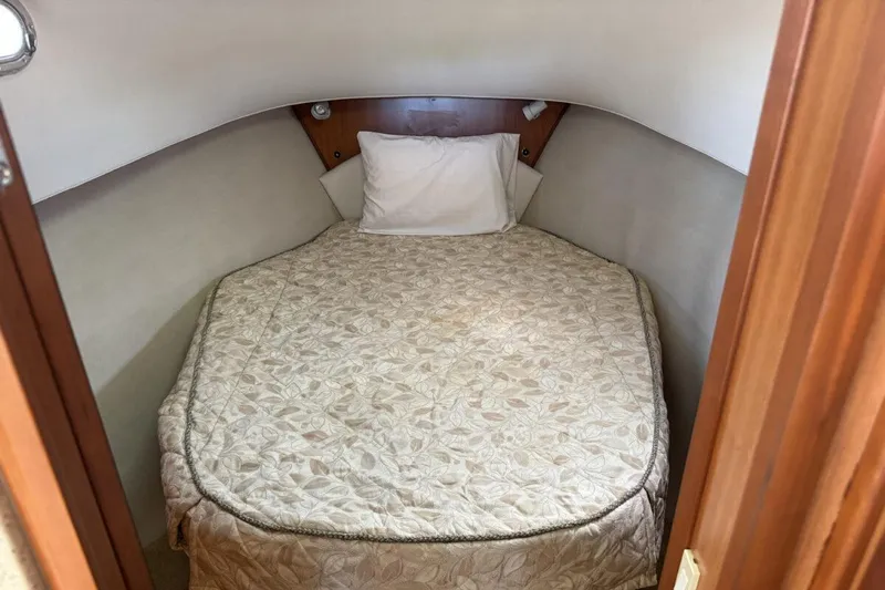 Getaway Yacht Photos Pics Cozy cabin bed in 2008 Mainship 34 Trawler Hardtop, featuring a patterned bedspread.
