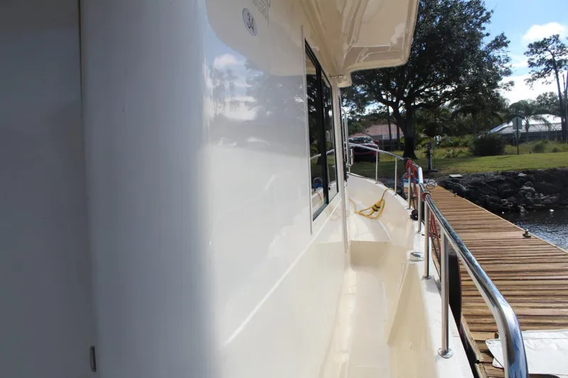 Getaway Yacht Photos Pics 2008 Mainship 34 Trawler Hardtop docked, side view with railing and walkway.