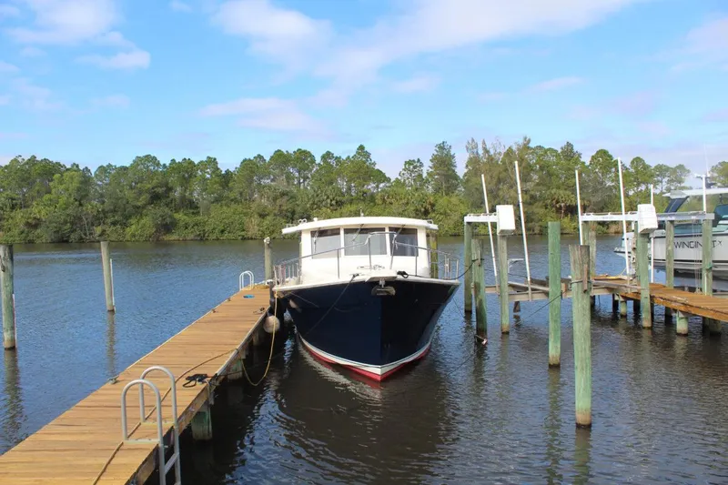 Getaway Yacht Photos Pics 2008 Mainship 34 Trawler Hardtop docked on a calm river.